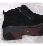 Black suede side-zip boot showing thick sole edge and front zipper closure.