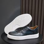 Men's leather sneaker outsole with textured tread, dark blue upper and white sole.