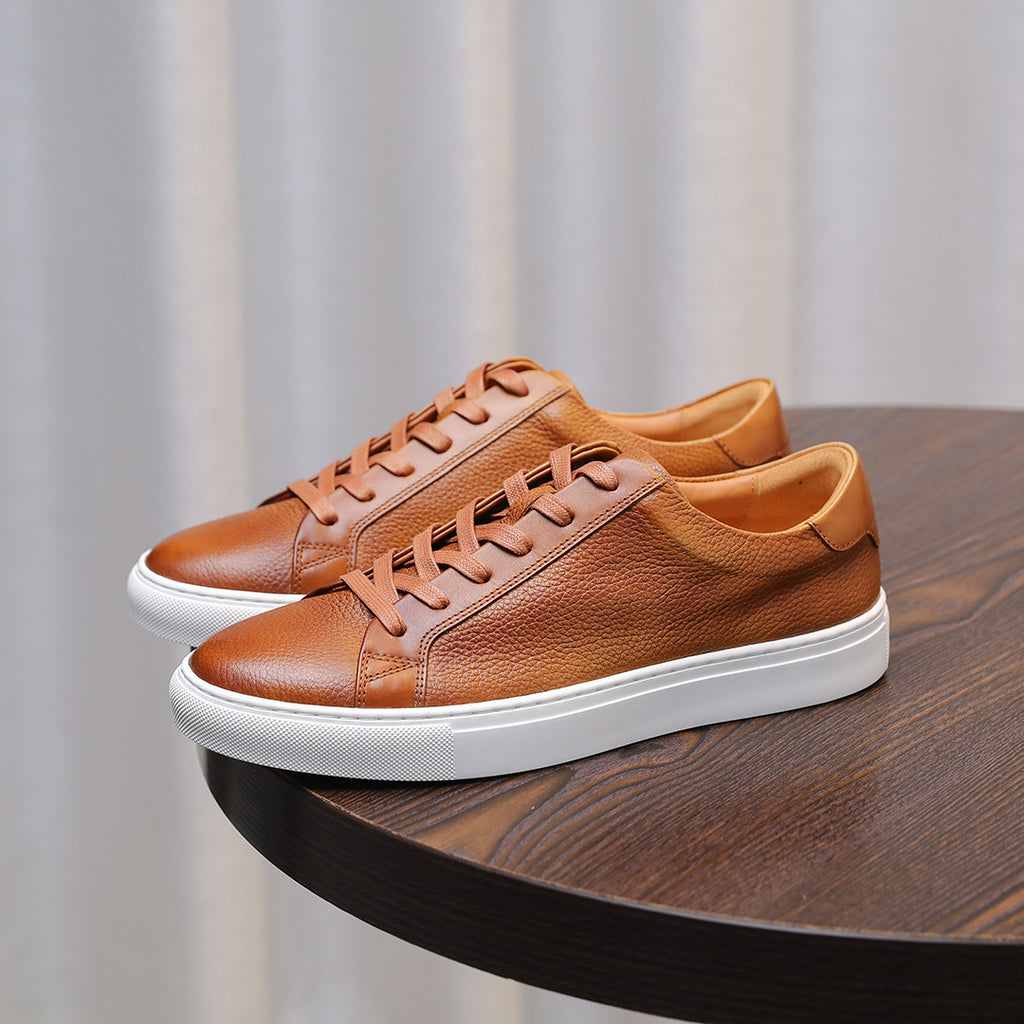Brown leather low-top sneakers with tan laces and white rubber sole