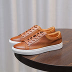 Brown leather low-top sneakers with tan laces and white rubber sole