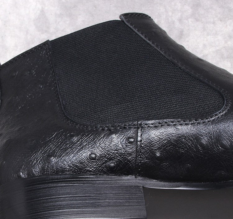 Black leather Chelsea boot close-up with elastic gore and stitching detail