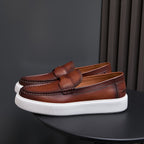 Men's brown leather slip-on sneakers with tassel-free moc toe and white platform sole.