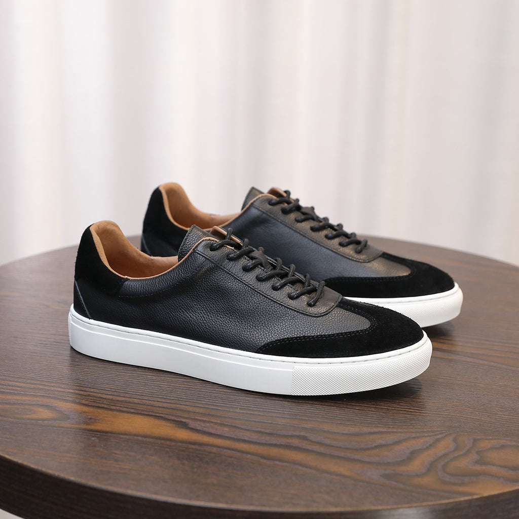 Men's leather sneakers in black with lace-up front and white rubber sole.