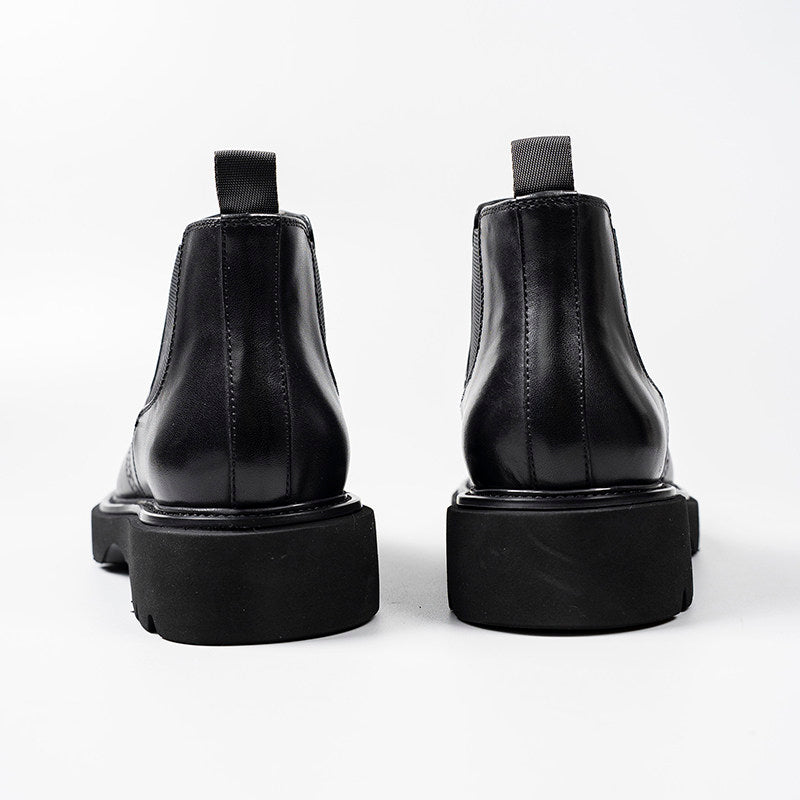 Black leather Chelsea dress boots with elastic side panels and thick rubber sole