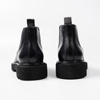 Black leather Chelsea dress boots with elastic side panels and thick rubber sole