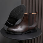 Dark brown chelsea dress boot sole with textured tread and elastic side gore