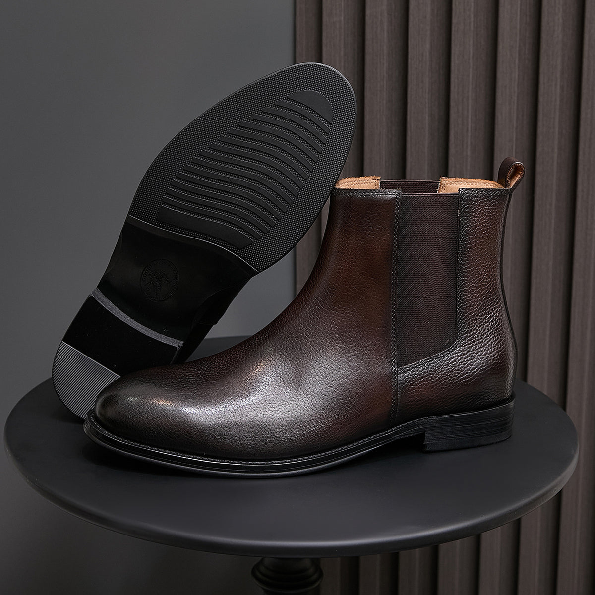 Dark brown chelsea dress boot sole with textured tread and elastic side gore
