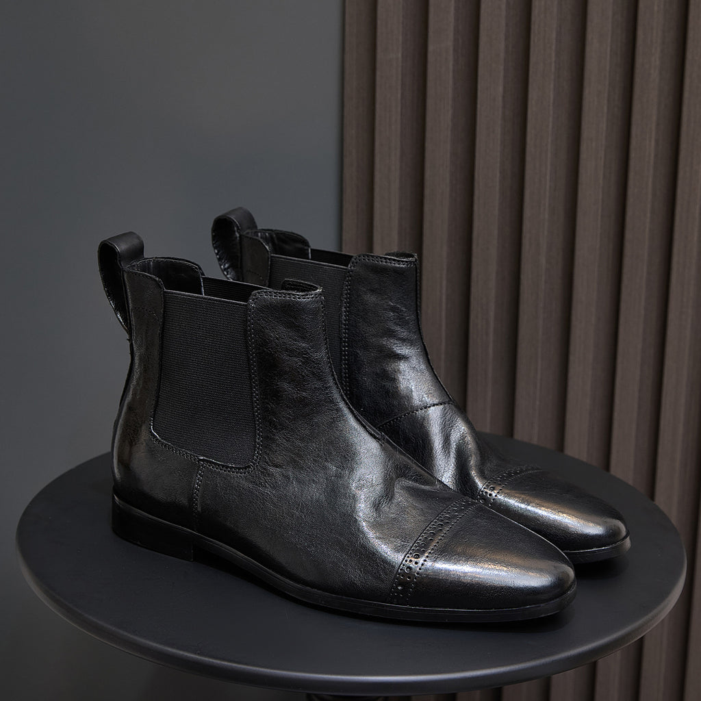 Pair of black pointed-toe Chelsea dress boots with elastic side panels