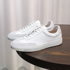 Men's white leather lace-up sneakers with low profile and textured rubber sole
