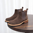 Pair of dark brown suede Chelsea boots with pointed toe, elastic gore, and lug sole