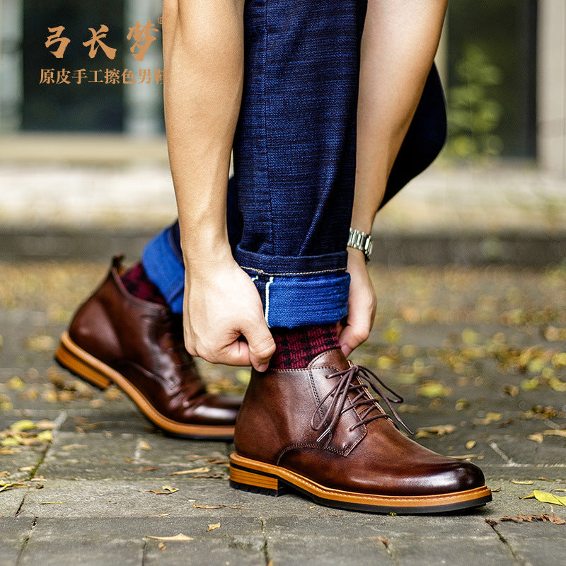 Men's brown leather lace-up chukka boots on feet, plain toe and tan sole trim