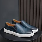 Men's dark blue slip-on leather sneakers with white rubber sole and textured upper