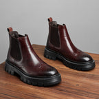 Pair of brown leather chelsea dress boots with elastic side panels and lug soles