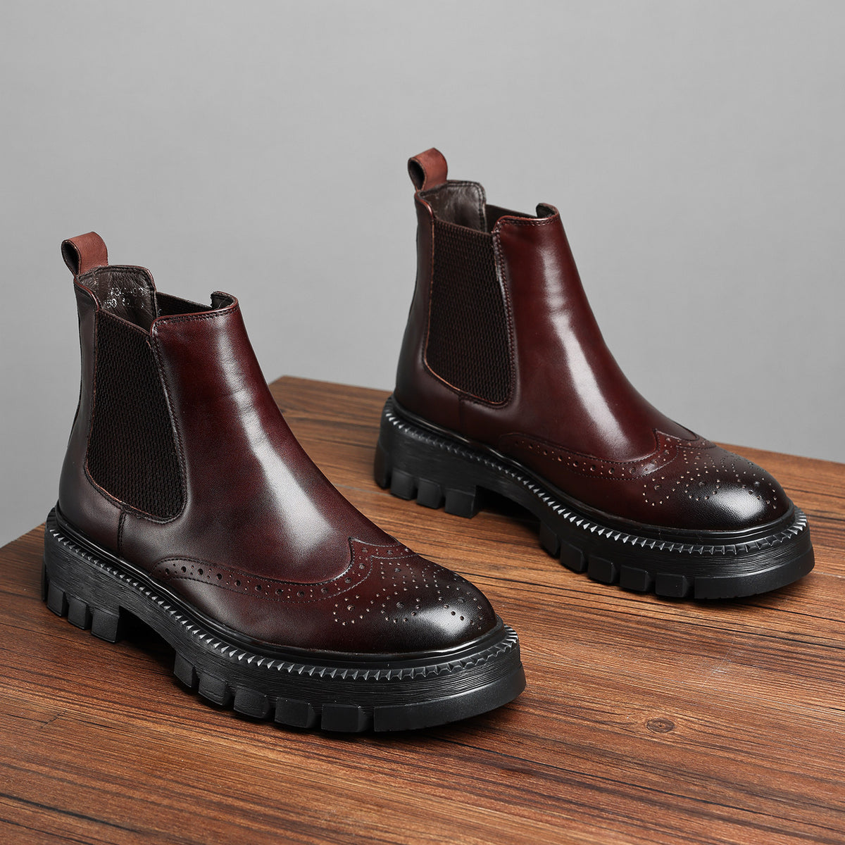 Pair of brown leather chelsea dress boots with elastic side panels and lug soles