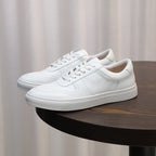 White men's leather sneakers with lace-up front and low-profile rubber sole
