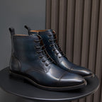 Men's dark leather lace-up dress boots pair with wingtip stitching and round pull tabs