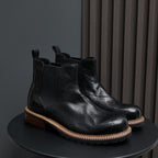 Men's pointed-toe suede Chelsea dress boots, black, pair on display with side elastic panels