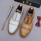 White and brown/tan lace-up oxford shoes with brogue/wingtip stitching and lug sole.