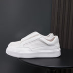 White genuine leather low-top sneakers with side panels and cushioned rubber sole