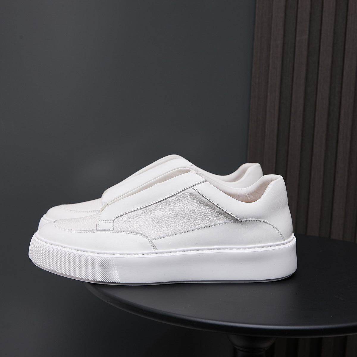 White genuine leather low-top sneakers with side panels and cushioned rubber sole