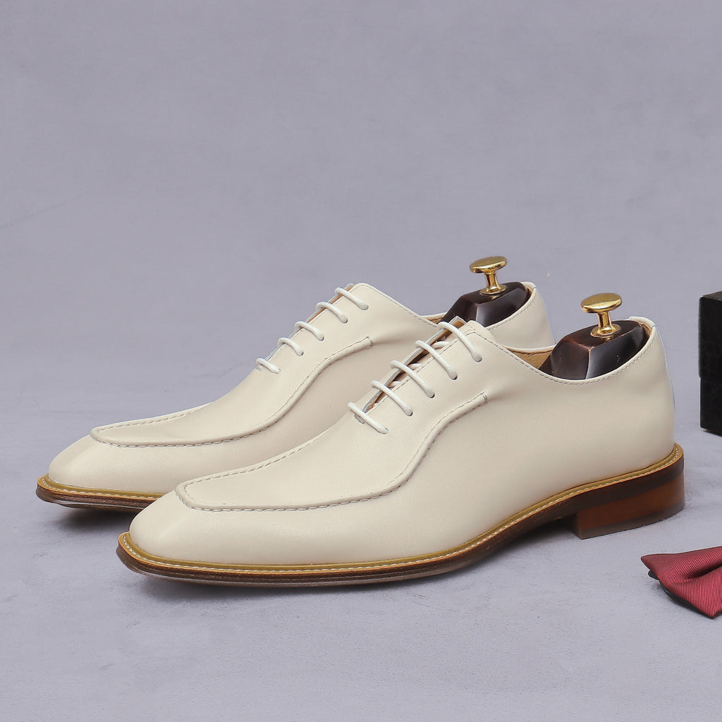 Beige chunky lug-sole brogue Oxford shoes, front lace-up profile with leather stitching