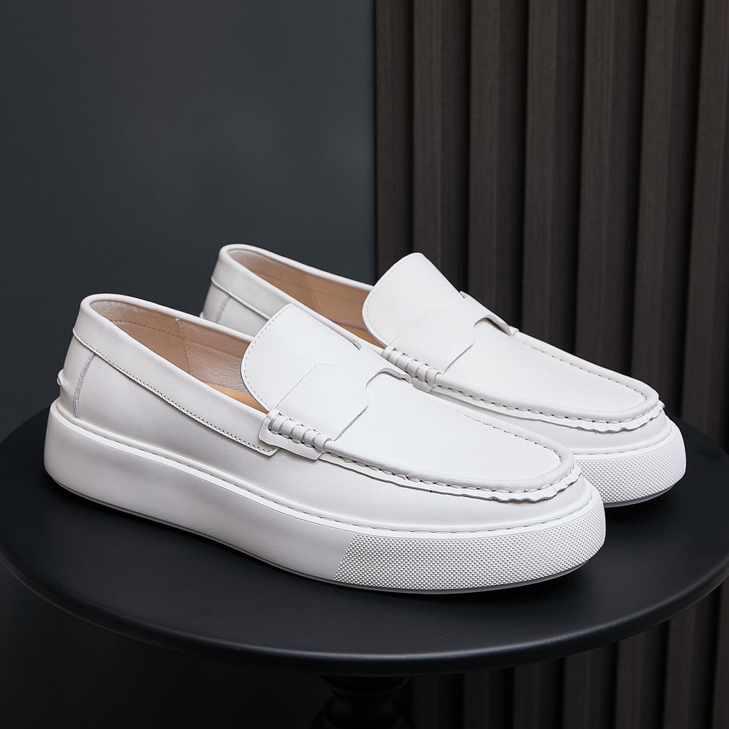 Pair of white leather slip-on sneakers with moccasin stitching and textured white sole