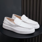 Pair of white leather slip-on sneakers with moccasin stitching and textured white sole