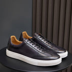 Men's leather sneakers, dark purple/black with white rubber sole and tan lining.