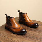 Men's brown leather chelsea dress boots, slip-on elastic panels, wingtip-style toe.