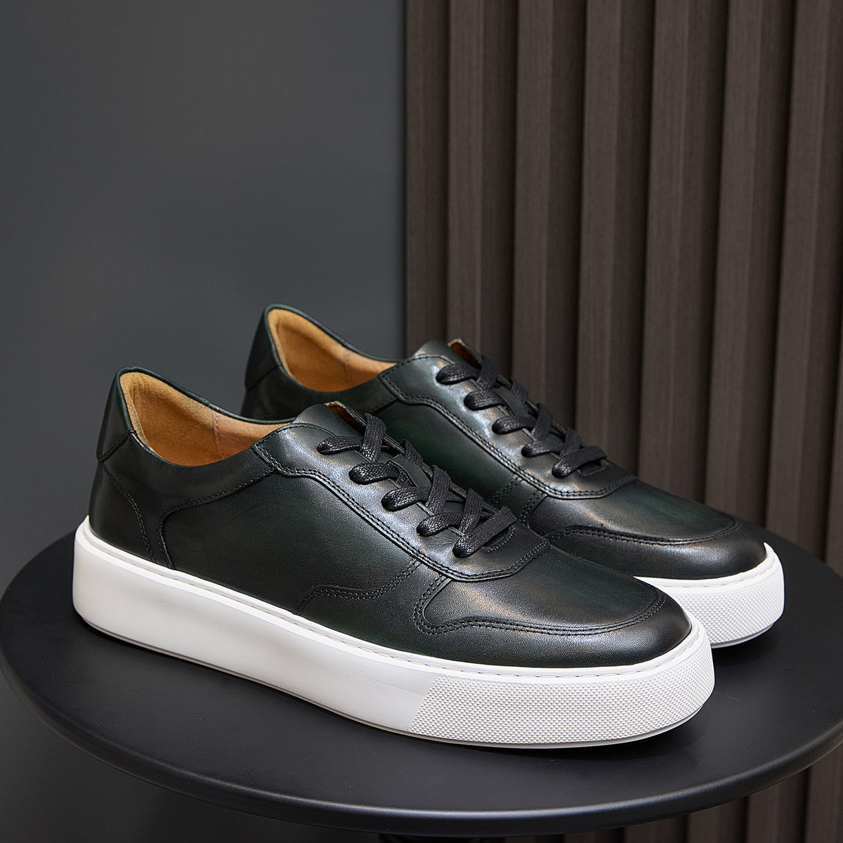 Men's dark green leather low-top sneakers with black laces and white platform sole
