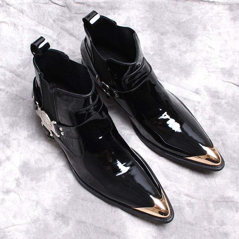 Pair of black glossy Chelsea dress boots with side gore and ornamental buckle hardware.