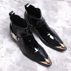 Pair of black glossy Chelsea dress boots with side gore and ornamental buckle hardware.