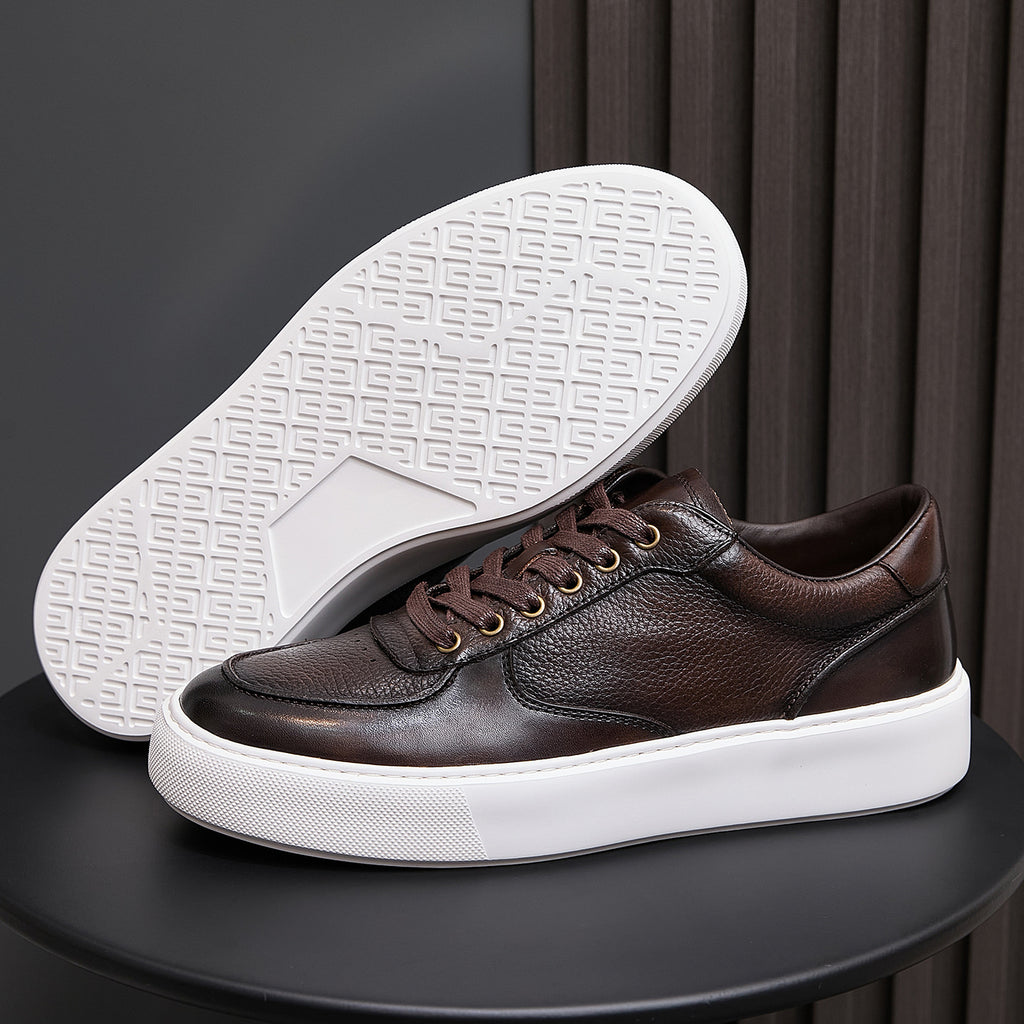Men's dark brown leather sneaker showing underside outsole tread with white rubber edge