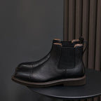 Black Chelsea dress boots with pointed toe, side elastic panels, and ankle pull tabs.