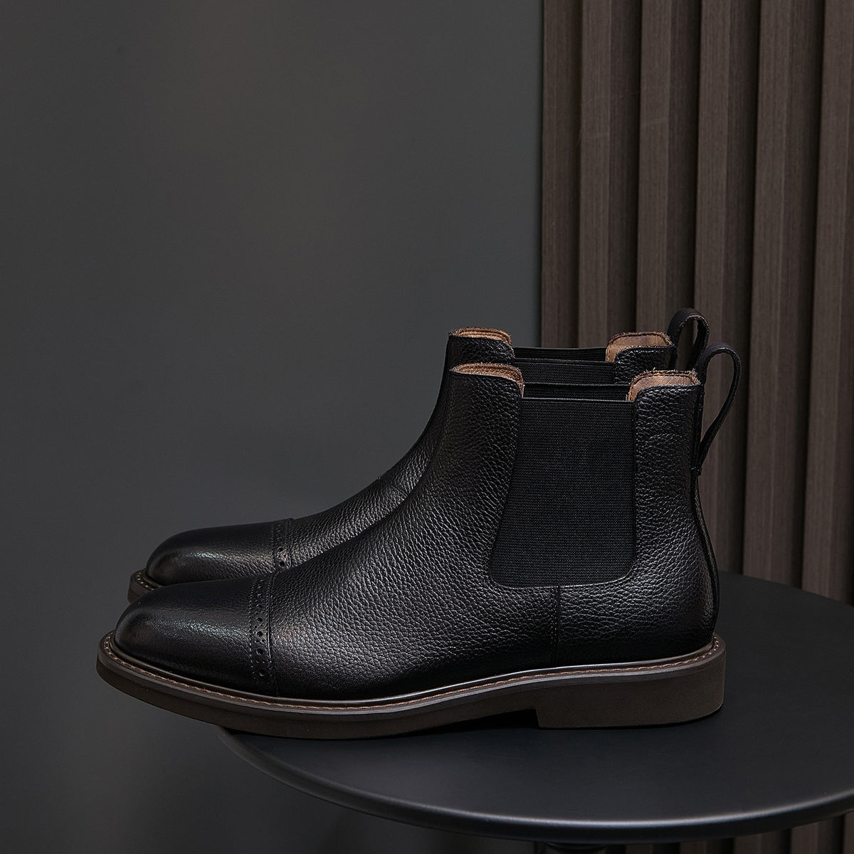 Black Chelsea dress boots with pointed toe, side elastic panels, and ankle pull tabs.