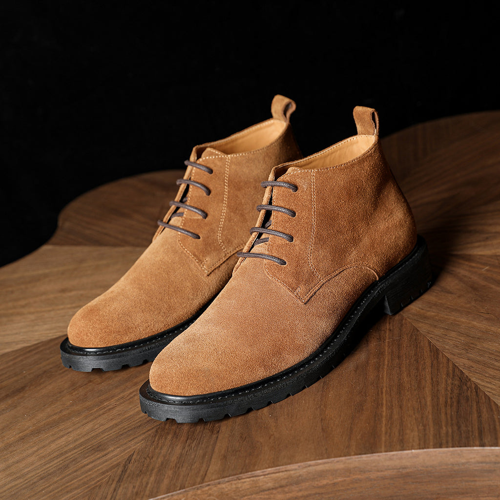 Men's tan suede chukka boots with lace-up front and contrast stitching