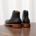 Black leather lace-up boots with side zipper and orange welt sole