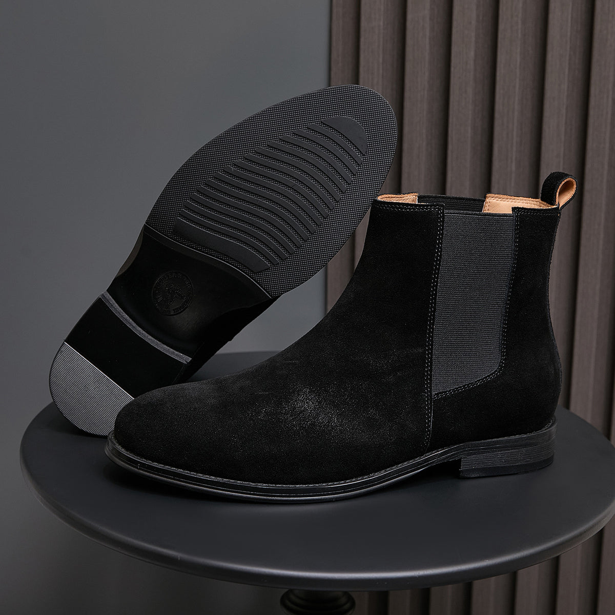 Black suede Chelsea boots with pointed toe, elastic sides, and textured rubber sole