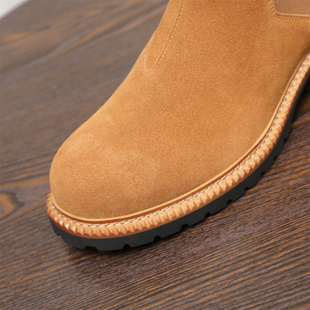 Tan suede Chelsea boot detail: pointed toe, stitched welt, and rubber tread outsole