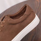 Brown suede leather sneaker, side view with lace-up and stitched quarter panels