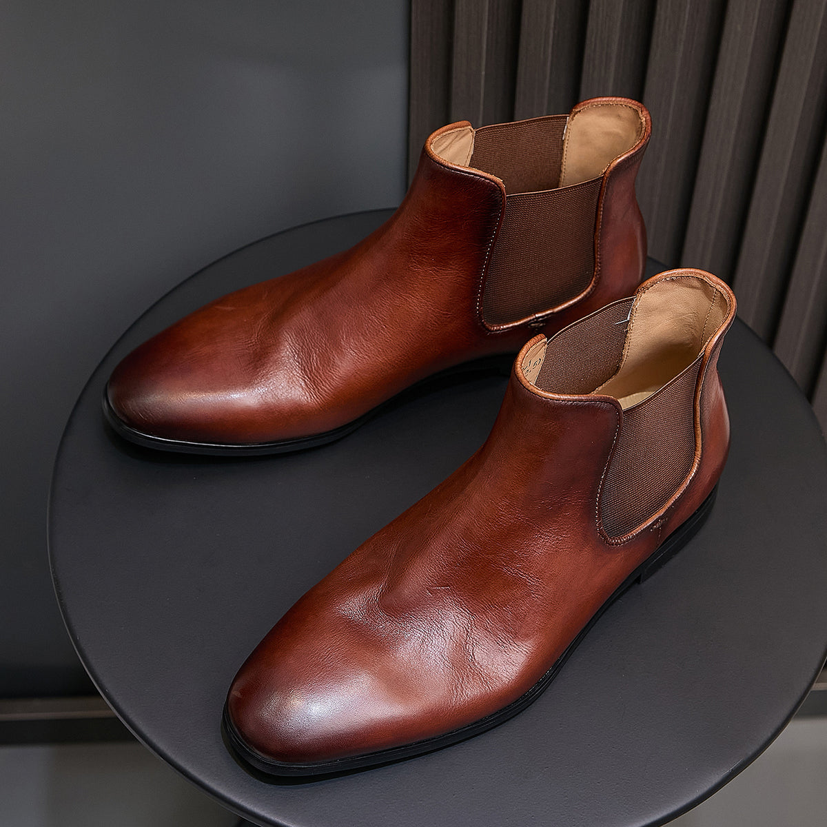 Brown pointed-toe Chelsea dress boots with elastic side panels and low stacked sole