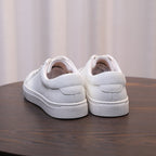 Men's white leather sneakers, back view with padded heel and grippy sole.