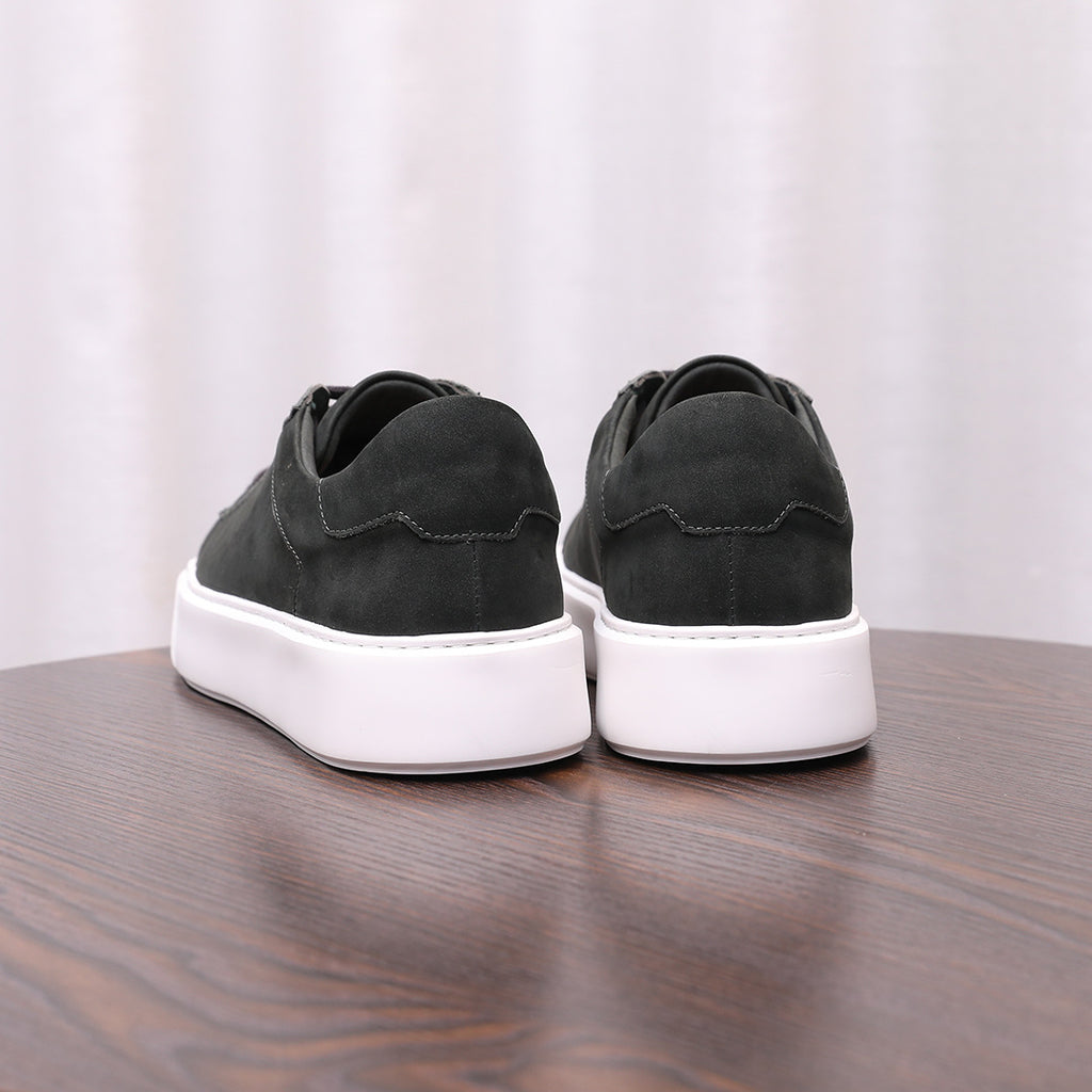 Pair of men's dark leather sneakers with white midsoles and lace-up uppers