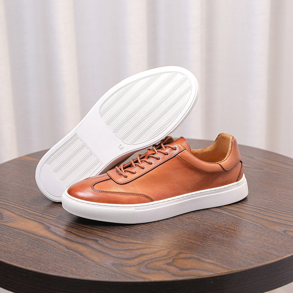 Brown leather lace-up sneakers with white outsole tread visible