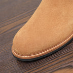 Tan suede boot toe with stitched edge and smooth rubber sole.