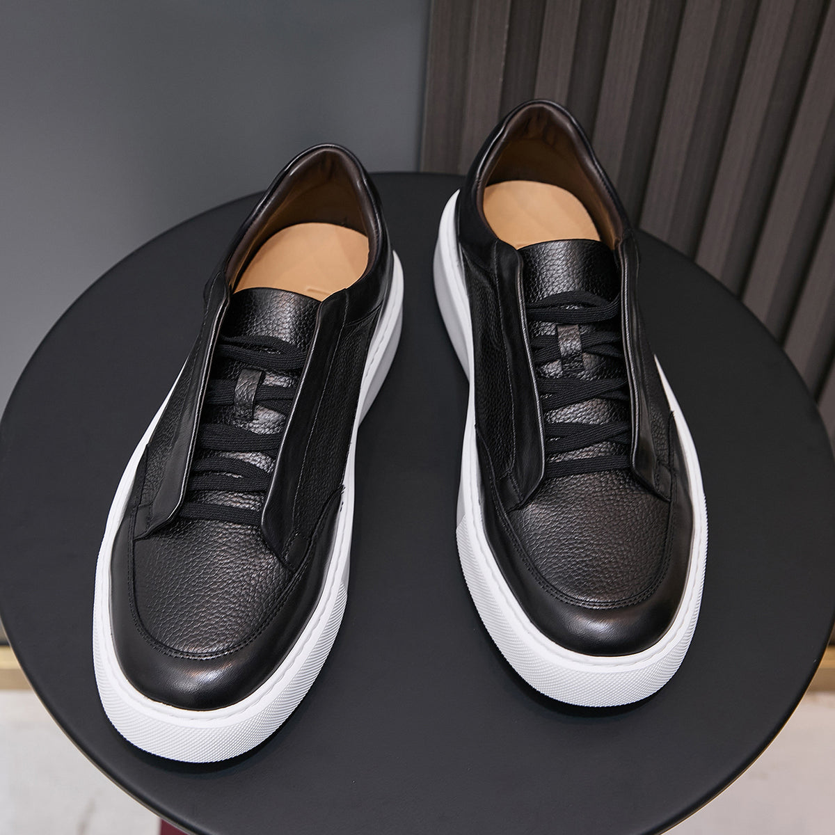 Men's genuine leather sneakers in black, lace-up with padded collar and white sole.