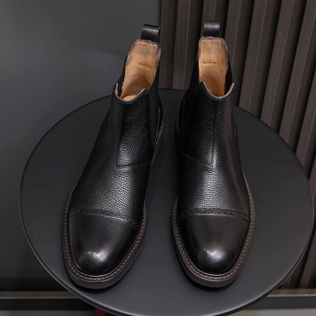 Black Chelsea dress boots, pointed toe, elastic gore, and stitched trim close-up