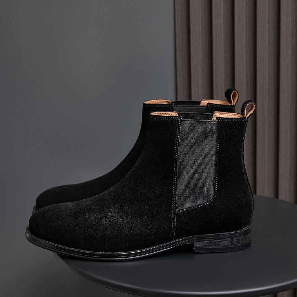 Black suede Chelsea boots with pointed toe and elastic side gore; pull tabs at top