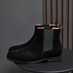 Black suede Chelsea boots with pointed toe and elastic side gore; pull tabs at top