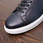 Close-up dark blue leather sneaker with black laces and white rubber sole